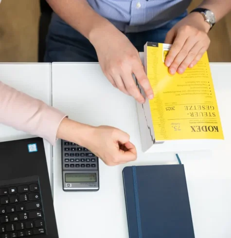 Schreibtisch mit Buch und Rechner