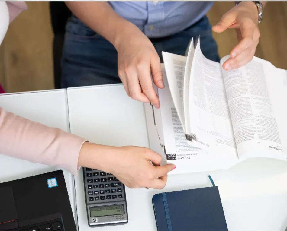 Foto von Buch und Rechner mit Händen